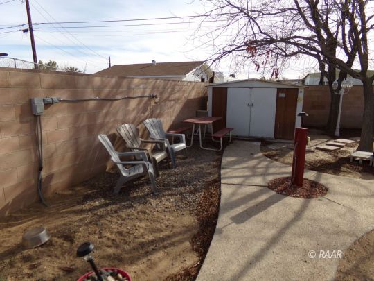837 West Bennett Street Ridgecrest, CA 93555 - Photo 3 of 6 a view of a backyard with table and chairs with wooden fence and plants