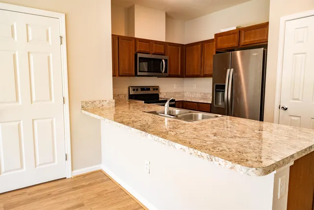 a kitchen with granite countertop a refrigerator and a sink