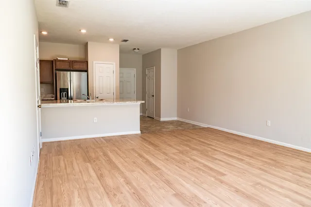 a view of a kitchen with white cabinets and wooden floor