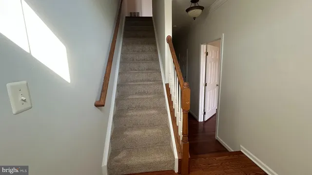 a view of a hallway with wooden floor and staircase