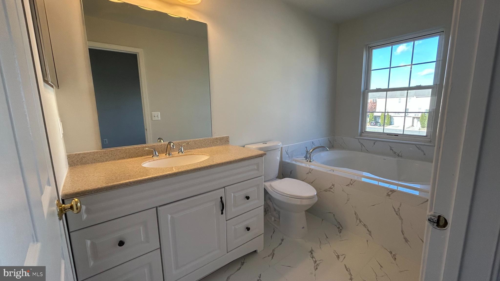42828 Nations Street Chantilly, VA 20152 - Photo 9 of 19 a bathroom with a granite countertop toilet a sink and a bathtub