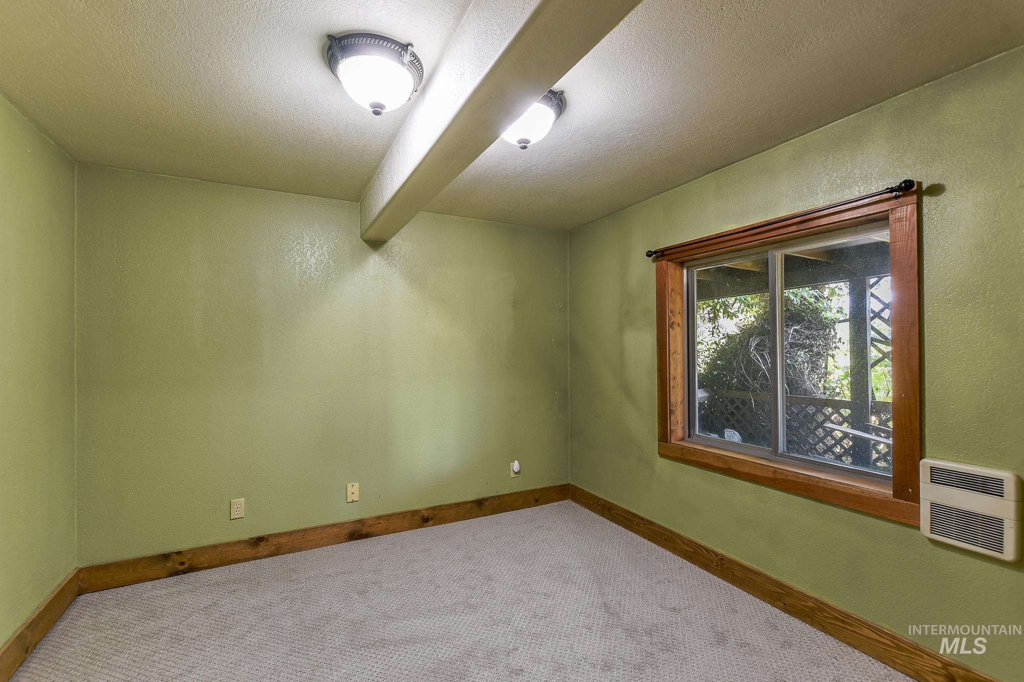 1045 Joyce Road Moscow, ID 83843 - Photo 34 of 50 Recessed ceiling light fixtures, exposed ceiling beam, wood-finish window trim, and carpeted flooring