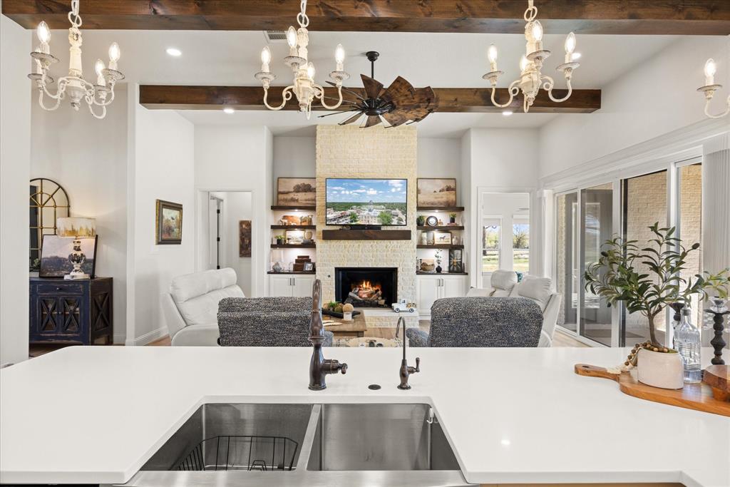 1700 Knox Road Tolar, TX 76476 - Photo 12 of 39 a living room with furniture a chandelier and a fireplace