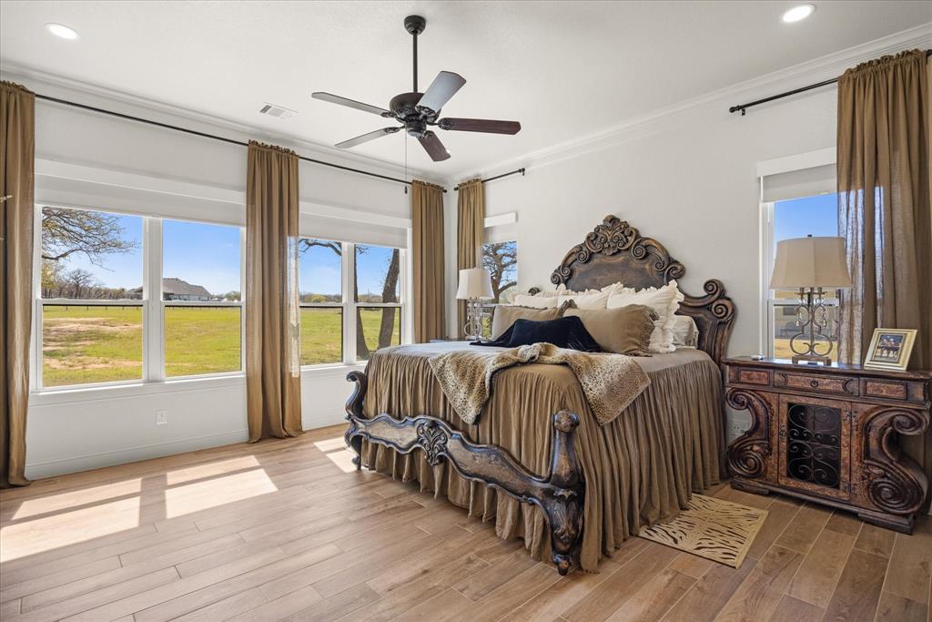 1700 Knox Road Tolar, TX 76476 - Photo 17 of 39 a bedroom with a large bed and a chandelier