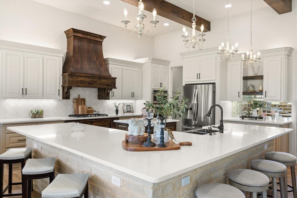 1700 Knox Road Tolar, TX 76476 - Photo 24 of 39 a kitchen with a dining table chairs and white cabinets