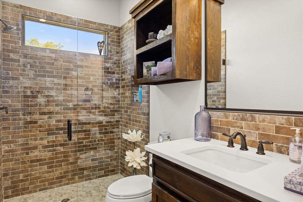 1700 Knox Road Tolar, TX 76476 - Photo 28 of 39 a bathroom with a sink a toilet and a mirror