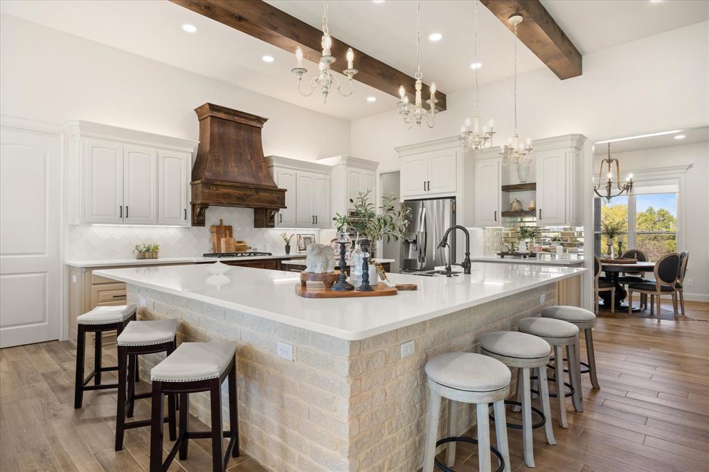 1700 Knox Road Tolar, TX 76476 - Photo 8 of 39 a kitchen with kitchen island a dining table chairs cabinets and sink