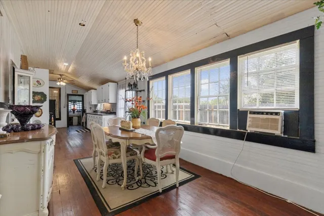 a living room with furniture a large window and a chandelier