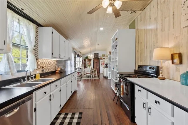 a kitchen with granite countertop white cabinets and white appliances