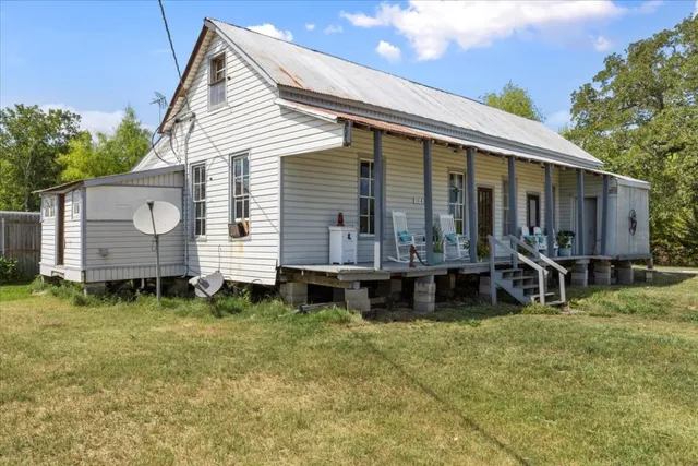 a view of a house with backyard and sitting area