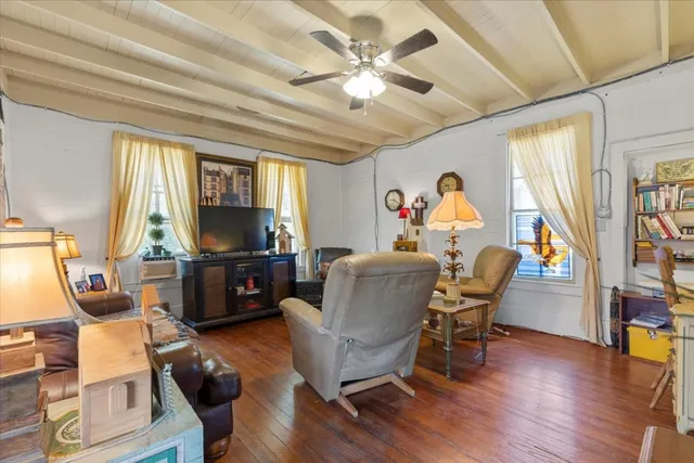 a living room with furniture flat screen tv and wooden floor