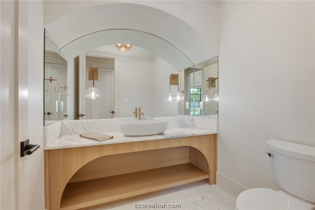 4212 Tuscany Court Bryan, TX 77802 - Photo 18 of 41 a bathroom with a granite countertop sink and a mirror with toilet