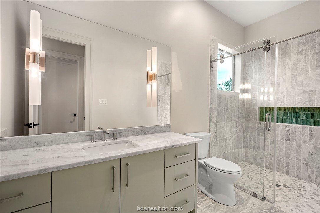 4212 Tuscany Court Bryan, TX 77802 - Photo 24 of 41 a bathroom with a granite countertop sink toilet a mirror a vanity and shower