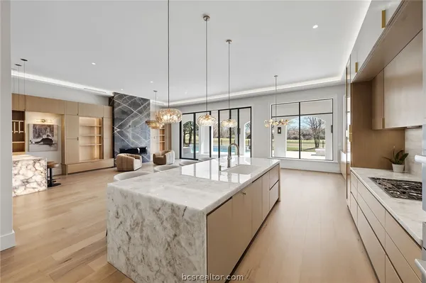 a kitchen with a dining table chairs and white cabinets