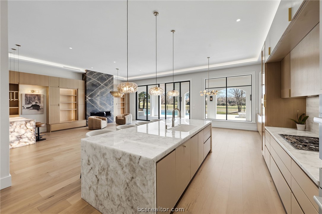 4212 Tuscany Court Bryan, TX 77802 - Photo 10 of 41 a large kitchen with kitchen island a large window a sink and stainless steel appliances