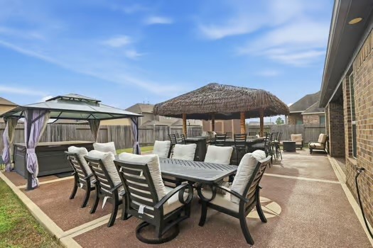 24714 Longwood Forest Drive Spring, TX 77373 - Photo 19 of 21 a view of a patio with table and chairs under an umbrella with a barbeque