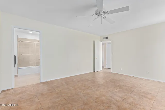 a view of an empty room and a ceiling fan