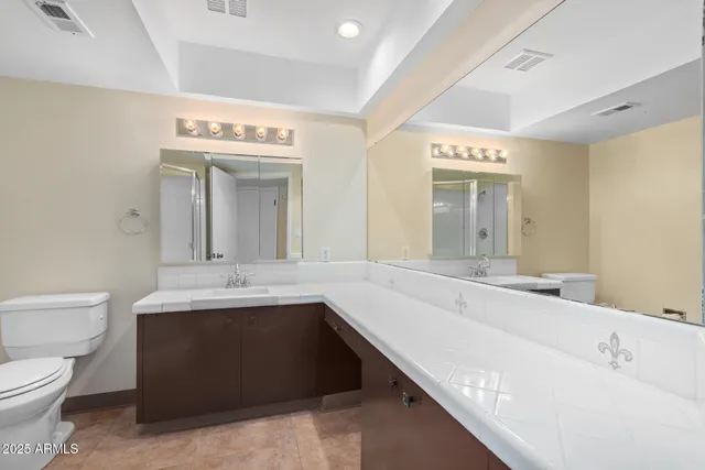 a spacious bathroom with a bathtub sink mirror and toilet