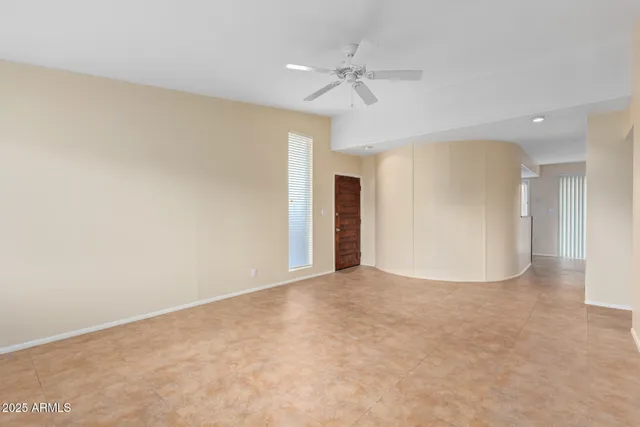 an empty room with a ceiling fan and a window