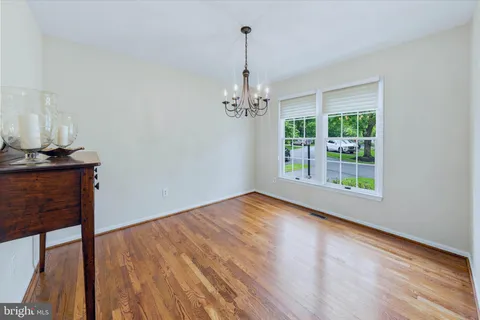 a view of a room with wooden floor fan and window
