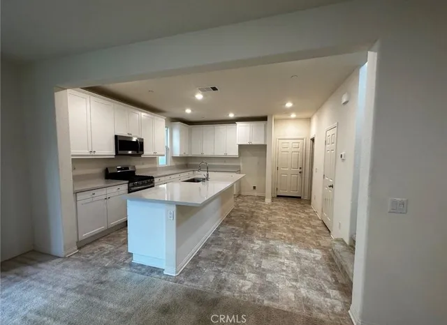 a large kitchen with a large counter top appliances and cabinets