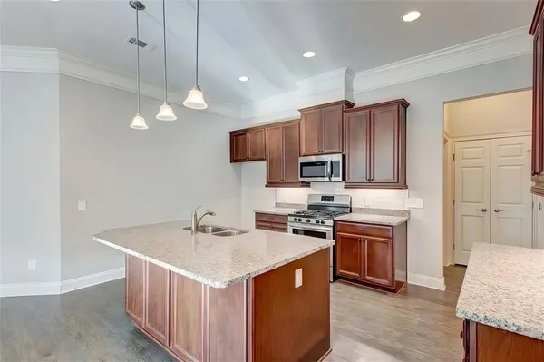 a kitchen with kitchen island granite countertop a sink stove and refrigerator