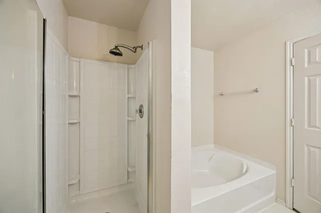 a en suite bathroom with a tub double vanity and mirrors