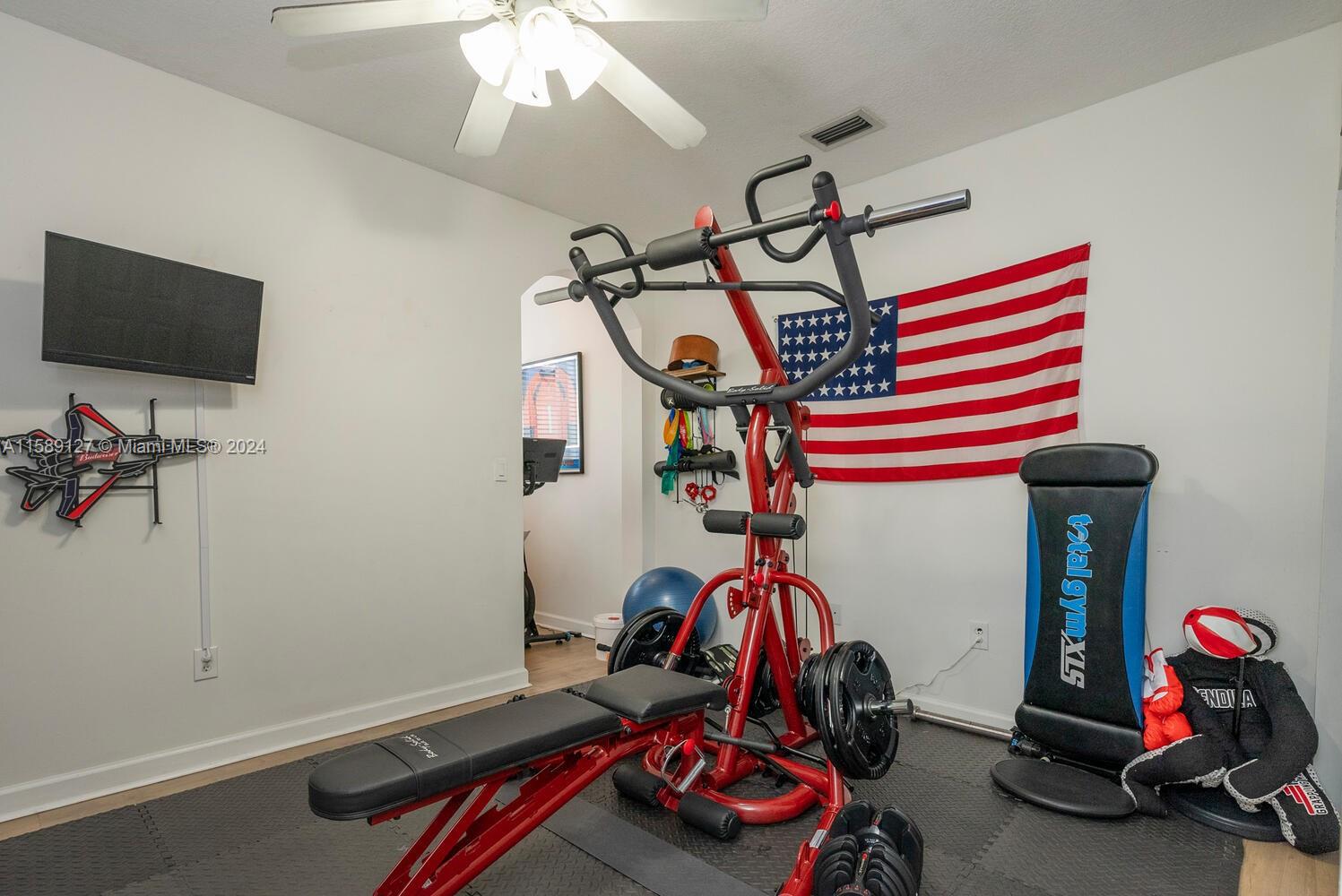 2000 Northeast 40th Road Homestead, FL 33033 - Photo 15 of 33 a room with gym equipment and a flat screen tv