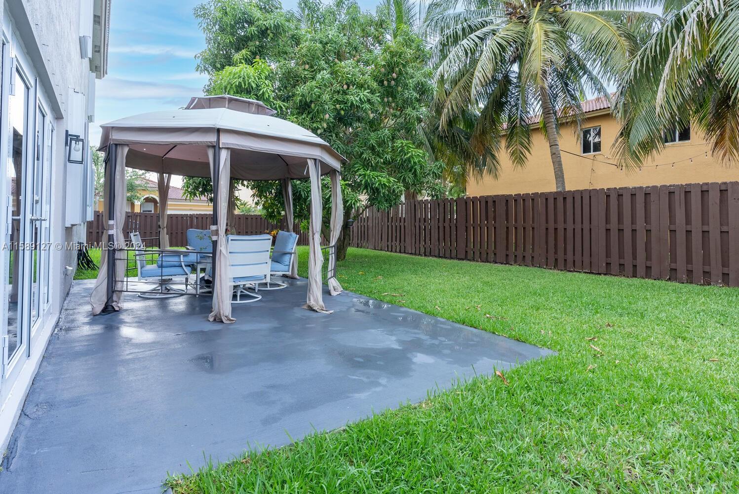 2000 Northeast 40th Road Homestead, FL 33033 - Photo 32 of 33 a view of a patio with a table and chairs under an umbrella