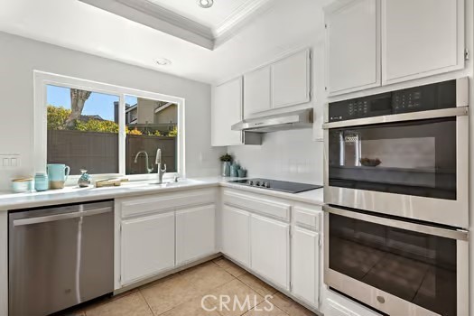 8 Caraway Irvine, CA 92604 - Photo 12 of 33 a kitchen with stainless steel appliances granite countertop white cabinets a sink and dishwasher