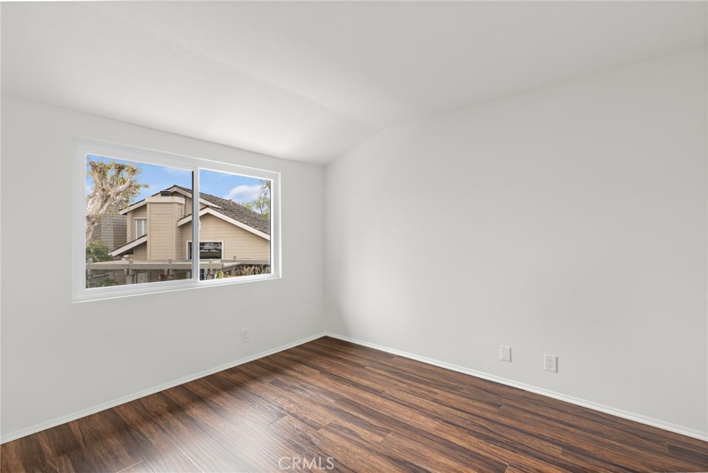 8 Caraway Irvine, CA 92604 - Photo 21 of 33 a view of an empty room with wooden floor and a window