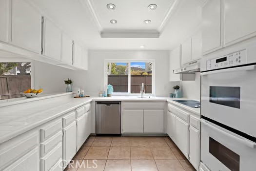 8 Caraway Irvine, CA 92604 - Photo 10 of 33 a kitchen with white cabinets appliances a sink and a window