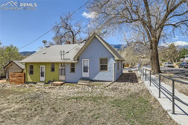 a front view of house with yard and trees around