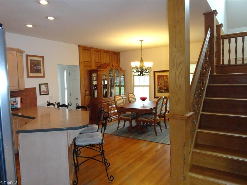 1122 Nance Road King, NC 27021 - Photo 7 of 30 Solid oak stairwell custom built from 1800's home place leads to upper level bedrooms. Landing provides views of kitchen/dining area to left and living room to right.