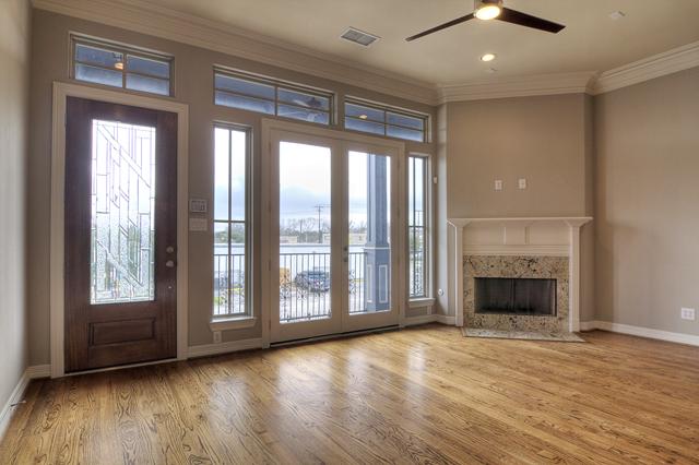 1138 Robbie Street Houston, TX 77009 - Photo 4 of 17 an empty room with wooden floor fireplace and windows