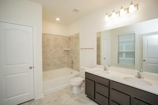 a bathroom with a tub a sink and mirror