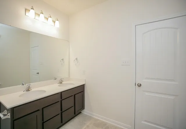 a bathroom with a double vanity sink and a mirror