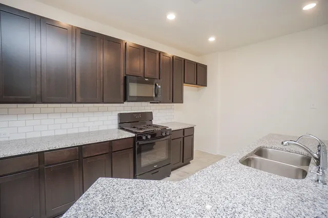 a kitchen with kitchen island a sink stainless steel appliances and cabinets