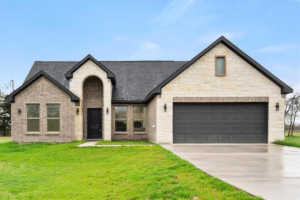a front view of a house with a yard and garage