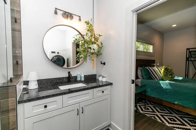 a bathroom with a granite countertop sink and a mirror