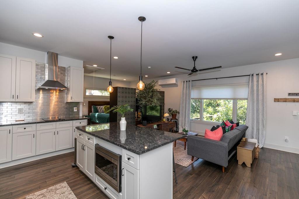 1084 Sanders Avenue Southeast, Unit B Atlanta, GA 30316 - Photo 8 of 28 a kitchen with kitchen island granite countertop a stove and a wooden floor