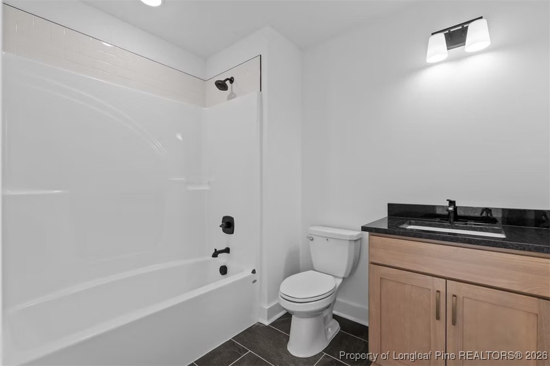9844 Rockfish Road Raeford, NC 28376 - Photo 12 of 32 a bathroom with a granite countertop toilet a sink and bathtub