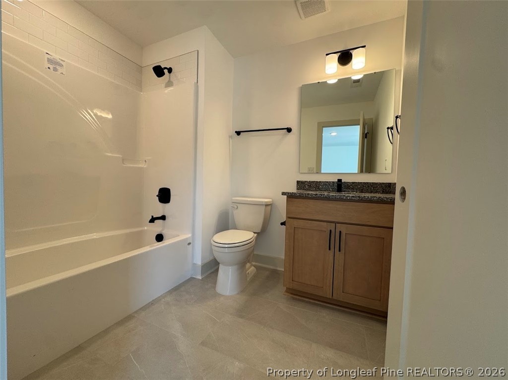9844 Rockfish Road Raeford, NC 28376 - Photo 30 of 32 a bathroom with a granite countertop toilet a sink and bathtub