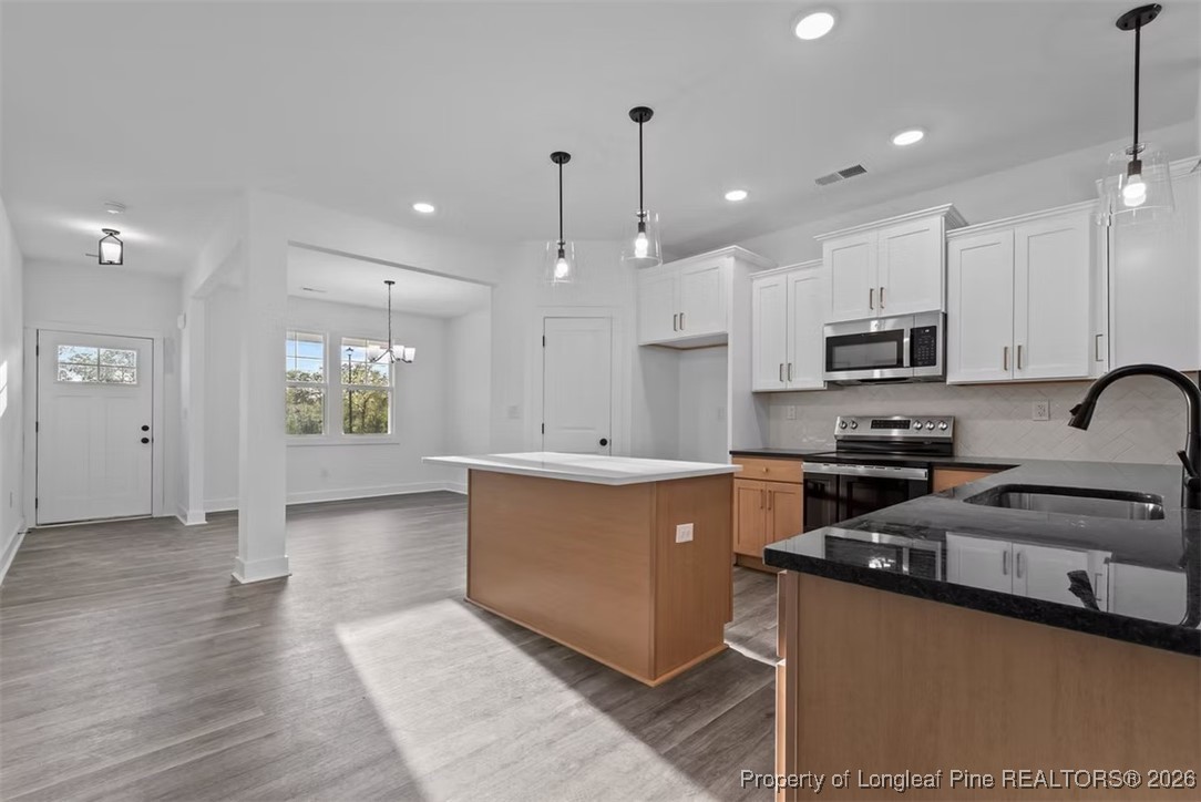 9844 Rockfish Road Raeford, NC 28376 - Photo 3 of 32 a kitchen with stainless steel appliances granite countertop a sink a stove and a refrigerator