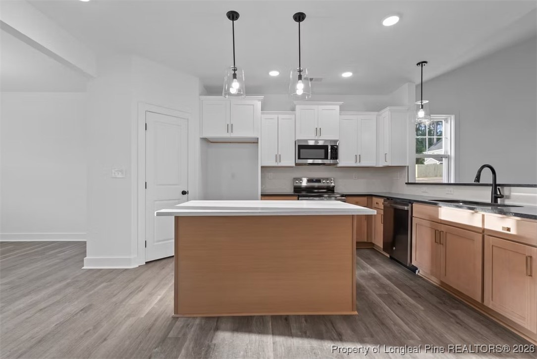 9844 Rockfish Road Raeford, NC 28376 - Photo 4 of 32 a kitchen with stainless steel appliances granite countertop a sink a stove a refrigerator and island with wooden floor