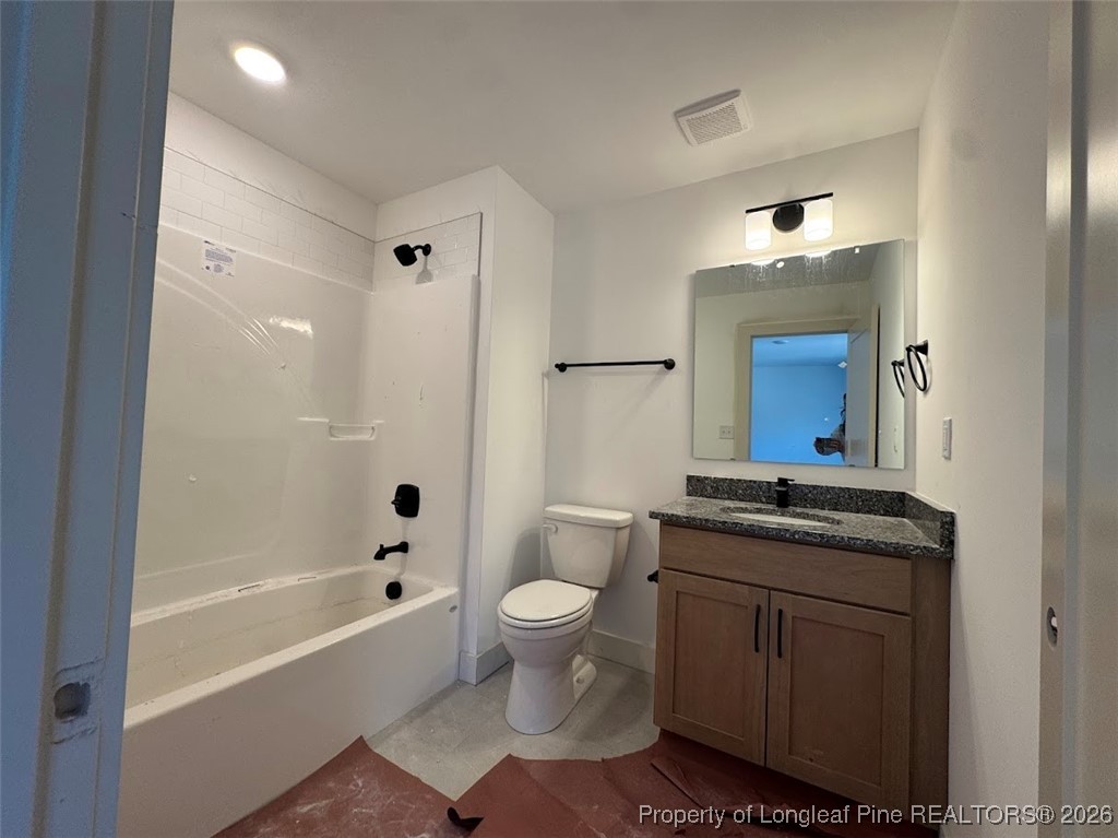 9844 Rockfish Road Raeford, NC 28376 - Photo 10 of 15 a bathroom with a granite countertop sink a toilet a mirror a bathtub and shower