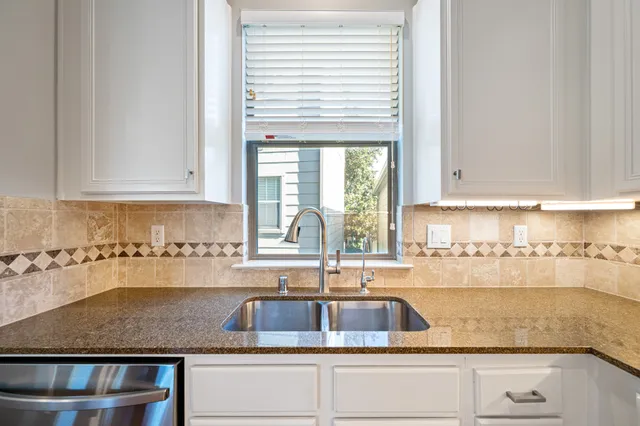a kitchen with granite countertop a sink and a window