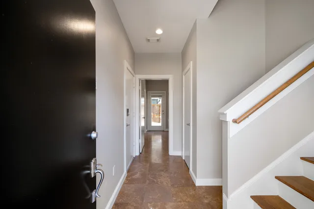a view of a hallway with wooden floor