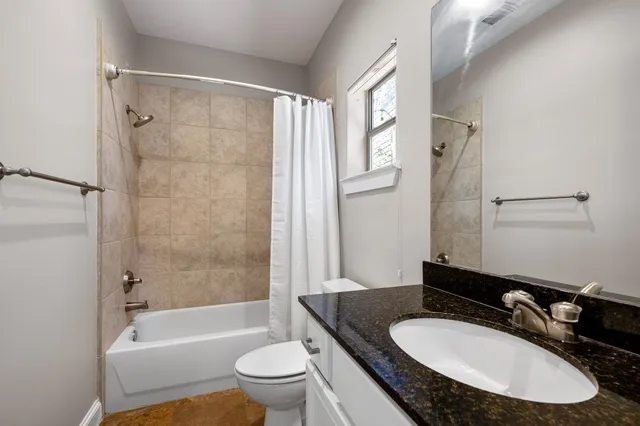 a bathroom with a granite countertop sink toilet and shower