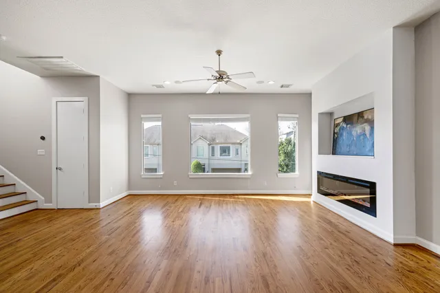 a view of livingroom with window wooden floor and a kitchen